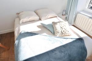 a bed with two pillows on it in a room at Napoléon Gare 1 STUDIO Lumineux ByLocly in Pontivy