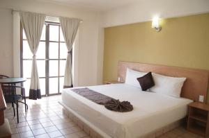 - une chambre avec un lit et une grande fenêtre dans l'établissement AM Amakal Hotel & Park, à Santa Cruz Huatulco