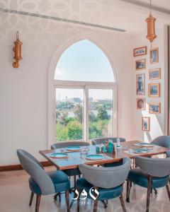 a dining room with a table and chairs and a window at Andalus Hotel in Baghdad
