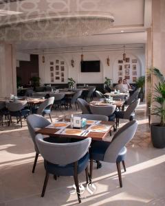 a restaurant with tables and chairs in a room at Andalus Hotel in Baghdad
