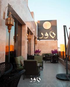 een patio met stoelen en tafels op een balkon bij Andalus Hotel in Bagdad