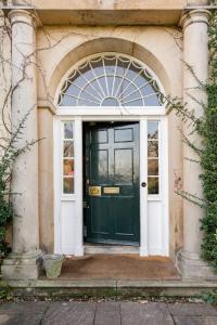 a green door in a building with an arch at Drylaw House, Grade A Listed Mansion near City Centre in Edinburgh