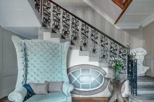 Drylaw House, Grade A Listed Mansion near City Centre في إدنبرة: درج مع كرسي ازرق وطاولة زجاج