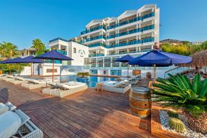 a resort with a pool and chairs and umbrellas at Meis Exclusive Hotel in Kaş