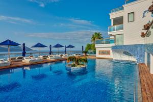 a swimming pool with chairs and umbrellas next to a building at Meis Exclusive Hotel in Kaş
