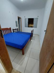 a bedroom with a blue bed and a window at Sobrado com vista ao mar in São Vicente