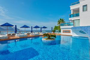 a pool at a resort with chairs and umbrellas at Meis Exclusive Hotel in Kaş