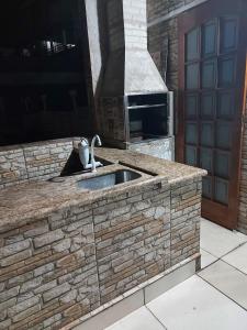 a stone kitchen with a sink and a stove at Sobrado com vista ao mar in São Vicente +15 photos