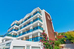 a large white building with a clock on it at Meis Exclusive Hotel in Kaş