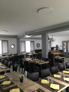 a dining room with tables and chairs and windows at A L'Orée du Bois in Bellerive-sur-Allier