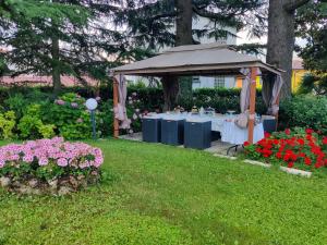 a gazebo with tables and flowers in a yard at Villa Laura in Lierna