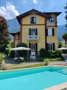 a villa with a swimming pool in front of a house at Villa Laura in Lierna