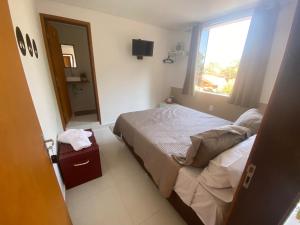 a small bedroom with a bed and a window at Pousada do Bosque in Boa Esperança