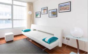 biały pokój z łóżkiem i oknem w obiekcie SyS Suites Nueva San Martin w mieście Santiago