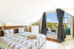 マルベーリャにある4 bedroom Holiday Penthouse near Puerto Banus, in Nueva Andaluciaのベッドルーム1室(ベッド1台、大きな窓付)