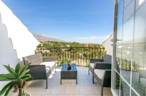 a balcony with chairs and a table with a view at 4 bedroom Holiday Penthouse near Puerto Banus, in Nueva Andalucia in Marbella