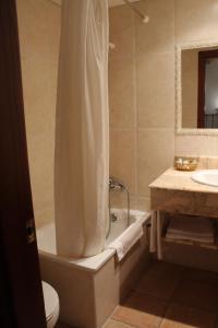 a bathroom with a tub and a toilet and a sink at Hotel La Villa in Requena