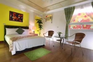 - une chambre avec un lit, une table et des chaises dans l'établissement Xiang Heng House, à Luodong