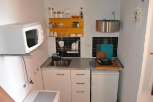 a small kitchen with a sink and a microwave at La Casa de Muñecas in Valle Gran Rey