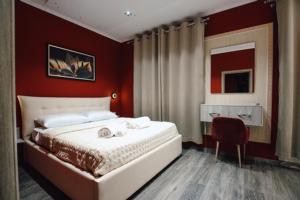 sypialnia z dużym łóżkiem i czerwoną ścianą w obiekcie Novs Hotel Rooms w Gjirokastrze