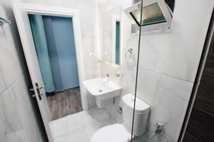 y baño con aseo y lavamanos. en Novs Hotel Rooms en Gjirokastër