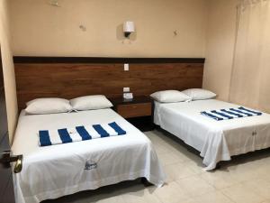 two beds in a hotel room with blue and white pillows at Apartamento Akamay 3 in El Cuyo