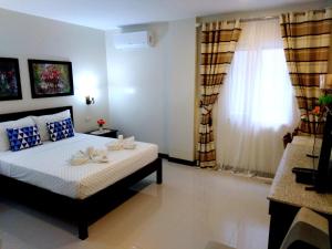 1 dormitorio con cama y ventana en Venezia Suites Hotel Iloilo, en Iloilo City