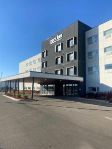 a building with a parking lot in front of it at Park Inn by Radisson Edmonton Airport in Leduc