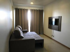 a living room with a couch and a flat screen tv at Vista Mar Premium in Ilhéus
