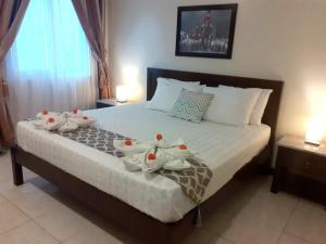 een slaapkamer met een bed met twee rubberen eenden erop bij Venezia Suites Hotel Iloilo in Iloilo City