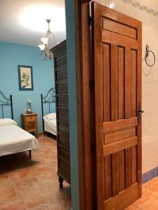 Habitación con dormitorio con puerta y cama en Casa Rural San Anton Cuenca, en El Provencio