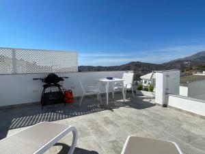 d'une terrasse avec une table et des chaises sur un balcon. dans l'établissement Casa Gato Azul, à Cómpeta