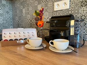 two cups on a table next to a coffee maker at Apartmány MAX in Vaclavov u Bruntalu