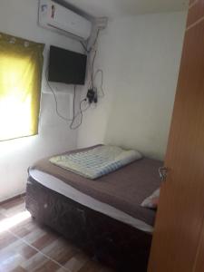 a small bedroom with a bed in a room with a window at Villa D Mariscos in Barra de Santo Antônio