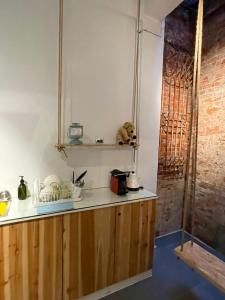 a kitchen with wooden cabinets and a brick wall at 阡陌-錦町民宿 in Tainan