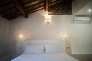 1 dormitorio con 1 cama blanca y 2 luces en la pared en THE ROMAN WAY OPERA en Roma