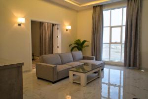 فندق راديانس جراند في أبها: غرفة معيشة مع أريكة وطاولة