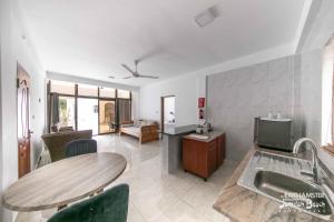 uma sala de estar com uma mesa e um lavatório em Jamelah Beach Guest House em Anse aux Pins