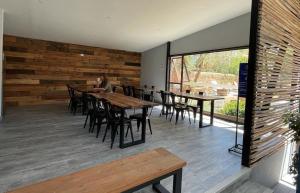a restaurant with wooden tables and chairs and a person at Ruta Elqui in Pisco Elqui