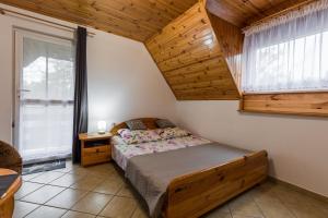 1 dormitorio con cama y techo de madera en Wypoczynek u Piotra, en Susiec