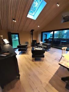 una gran sala de estar con sofás y tragaluz. en Le gîte du Parc, en Villers-devant-Orval