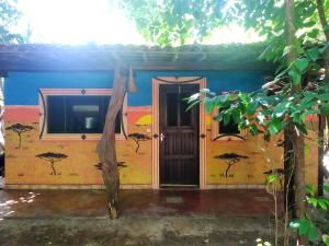 a house with a painting on the side of it at Lagarto Na Banana Hostel in Pipa