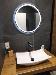 La salle de bains est pourvue d'un lavabo blanc et d'un miroir. dans l'établissement Le gîte du Parc, à Villers-devant-Orval