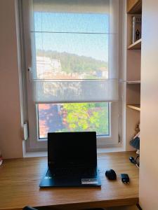 a laptop sitting on a desk in front of a window at LUXURIOUS ONE BEDROOM STUDIO IN TOP CENTER in Blagoevgrad