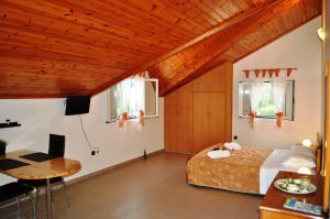 Mari-Christi Apartments في بوروس: غرفة نوم بسرير وطاولة ومكتب