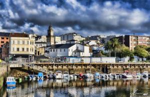 a group of boats docked in the water near a city at PISO AMPLIO A 100 M DE LA PLAYA in Foz