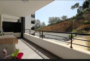 a room with a balcony with a view of a hill at T3 moderne et spacieux à BASTIA in Bastia