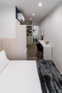 a bedroom with a white bed and a white desk at Residence le Pastel Jeanne d'Arc in Toulouse