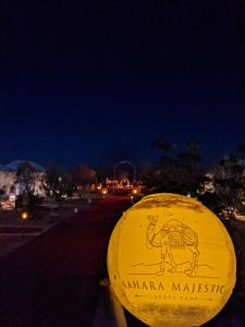 a yellow sign with an elephant on it at night at Sahara Majestic Luxury Camp in Merzouga