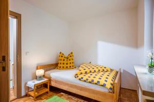 a bedroom with a bed and two yellow pillows at Ferienwohnung Böck in Kiefersfelden
